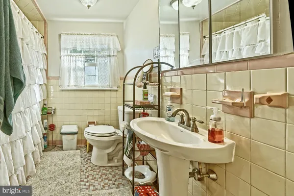 a bathroom with a sink and mirror with toilet