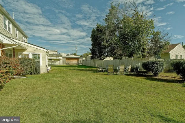 a view of a backyard with table and chairs and a tree