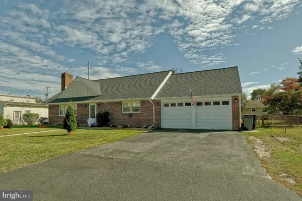 a view of an house with backyard and trees in the background