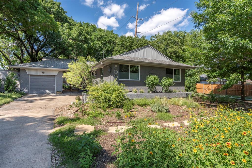 800 Nottingham Drive Richardson, TX 75080 - Photo 1 of 1 View of front of property featuring concrete driveway, fence, brick siding, a garage, and roof with shingles