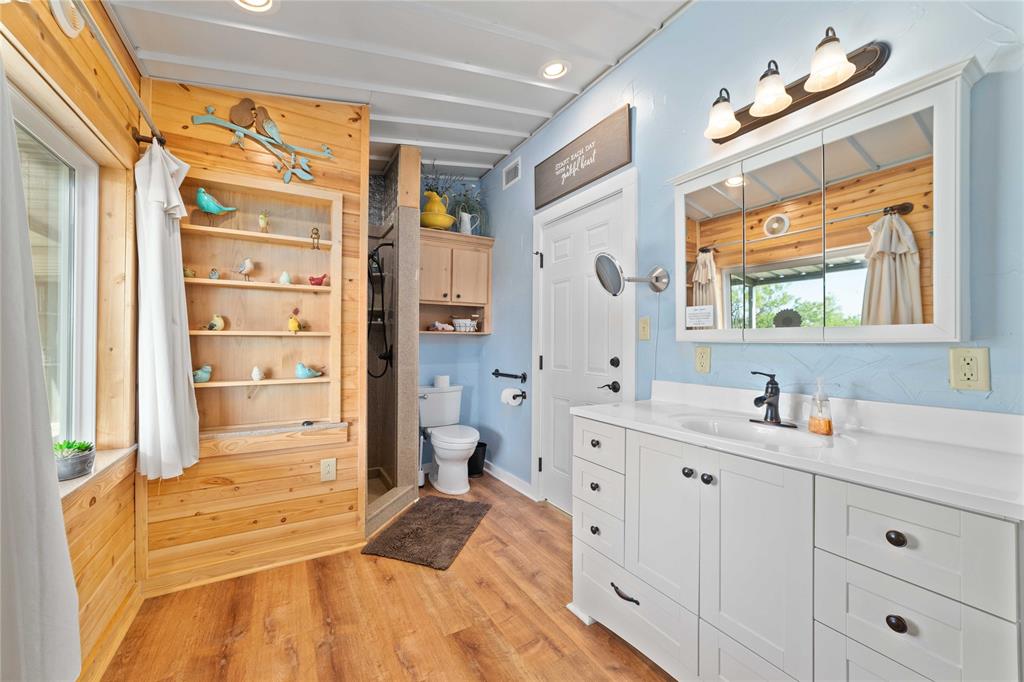 970 County Road 256 Coleman, TX 76834 - Photo 21 of 35 a spacious bathroom with a double vanity sink a mirror and a bathtub
