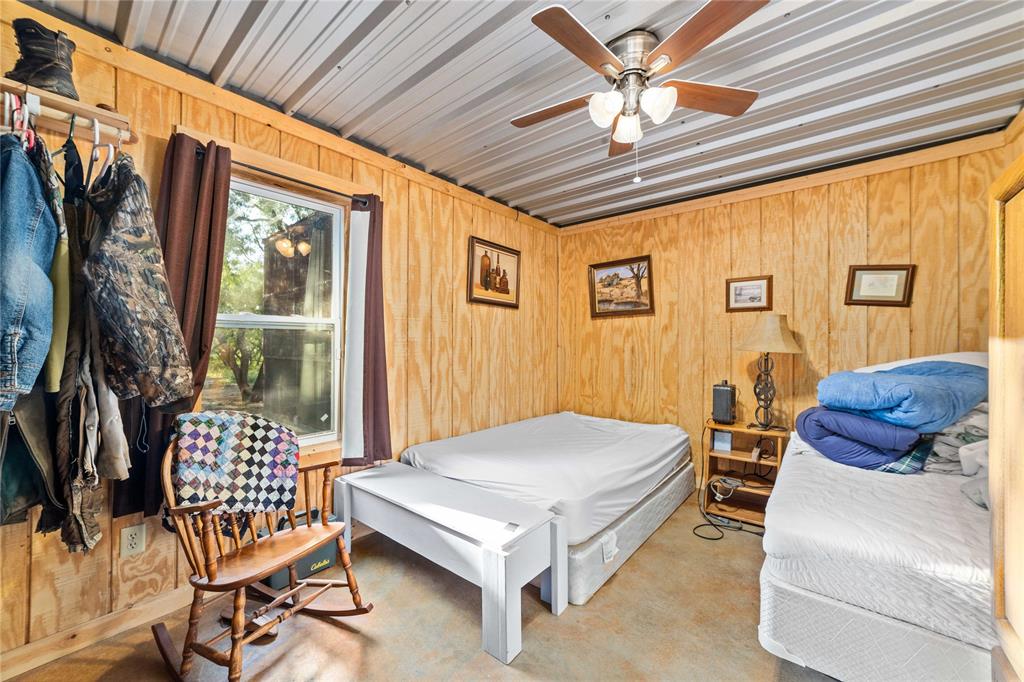 970 County Road 256 Coleman, TX 76834 - Photo 34 of 35 a bedroom with a bed and a chandelier