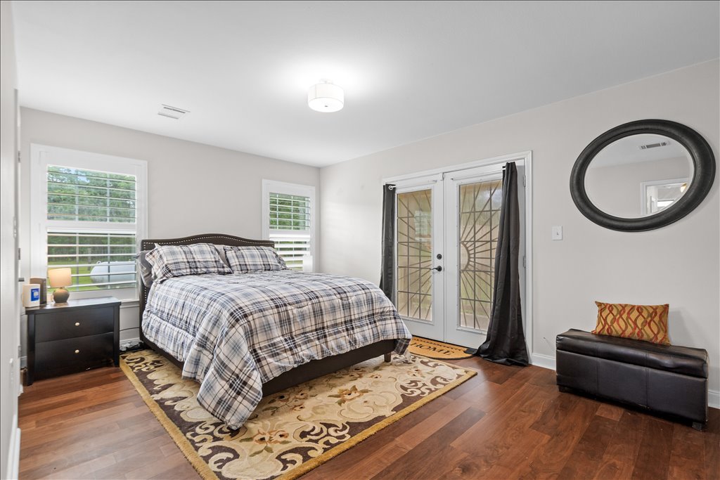 608 Whistleville Road Flatonia, TX 78941 - Photo 8 of 26 Welcome to the primary bedroom! It’s a very generous size with plenty of space and double French doors that open up directly to the outside—imagine waking up and walking right out to enjoy your morning coffee.