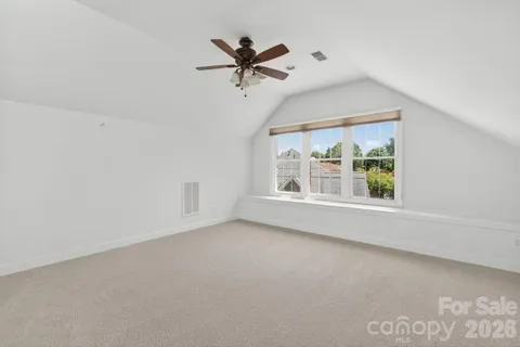 an empty room with a ceiling fan and window