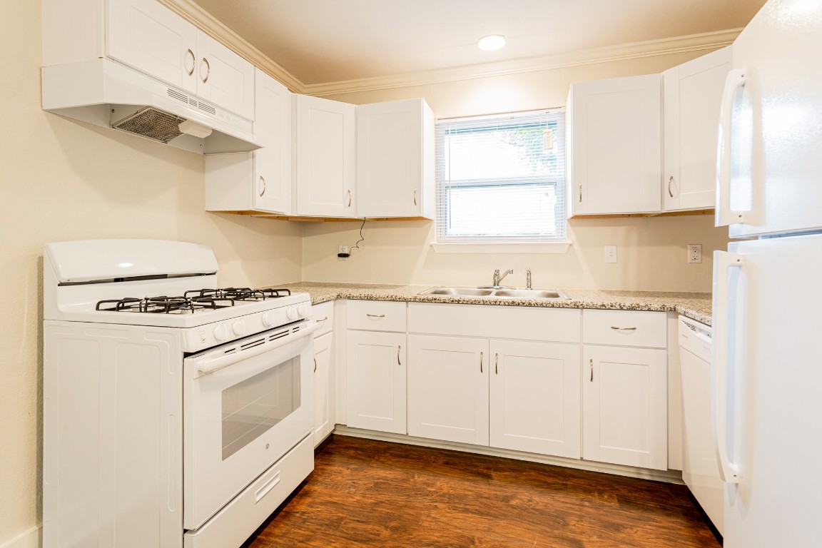 1909 Morrow Street, Unit B Austin, TX 78757 - Photo 13 of 16 a kitchen with granite countertop white cabinets and white appliances