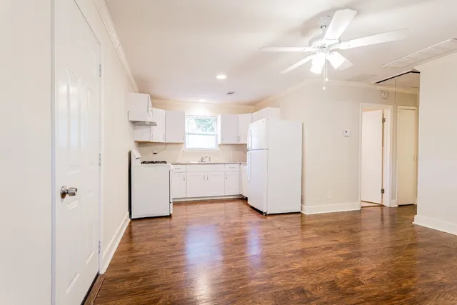 a view of a kitchen with wooden floor and a window