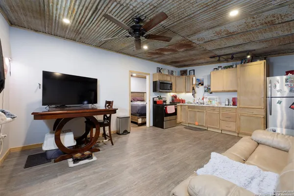 a living room with furniture kitchen view and a flat screen tv