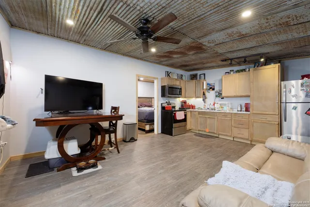 a living room with furniture kitchen view and a flat screen tv