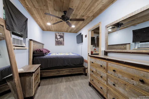 a bedroom with a bed dresser and a flat screen tv