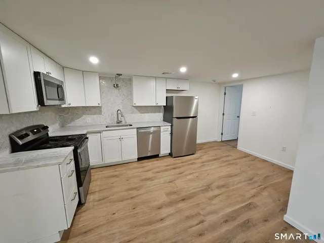 a kitchen with stainless steel appliances a refrigerator stove microwave and sink