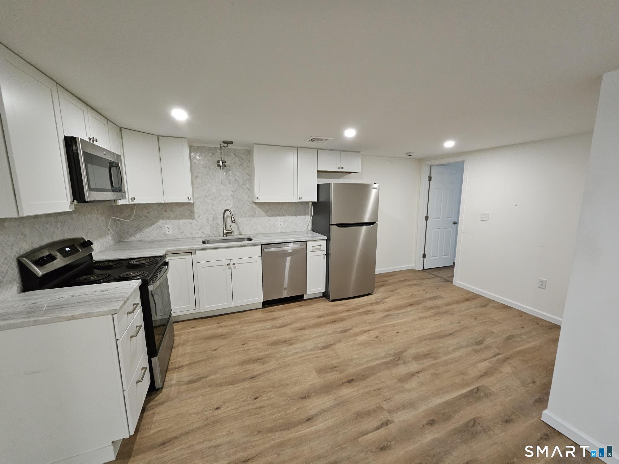 a kitchen with stainless steel appliances a refrigerator stove microwave and sink