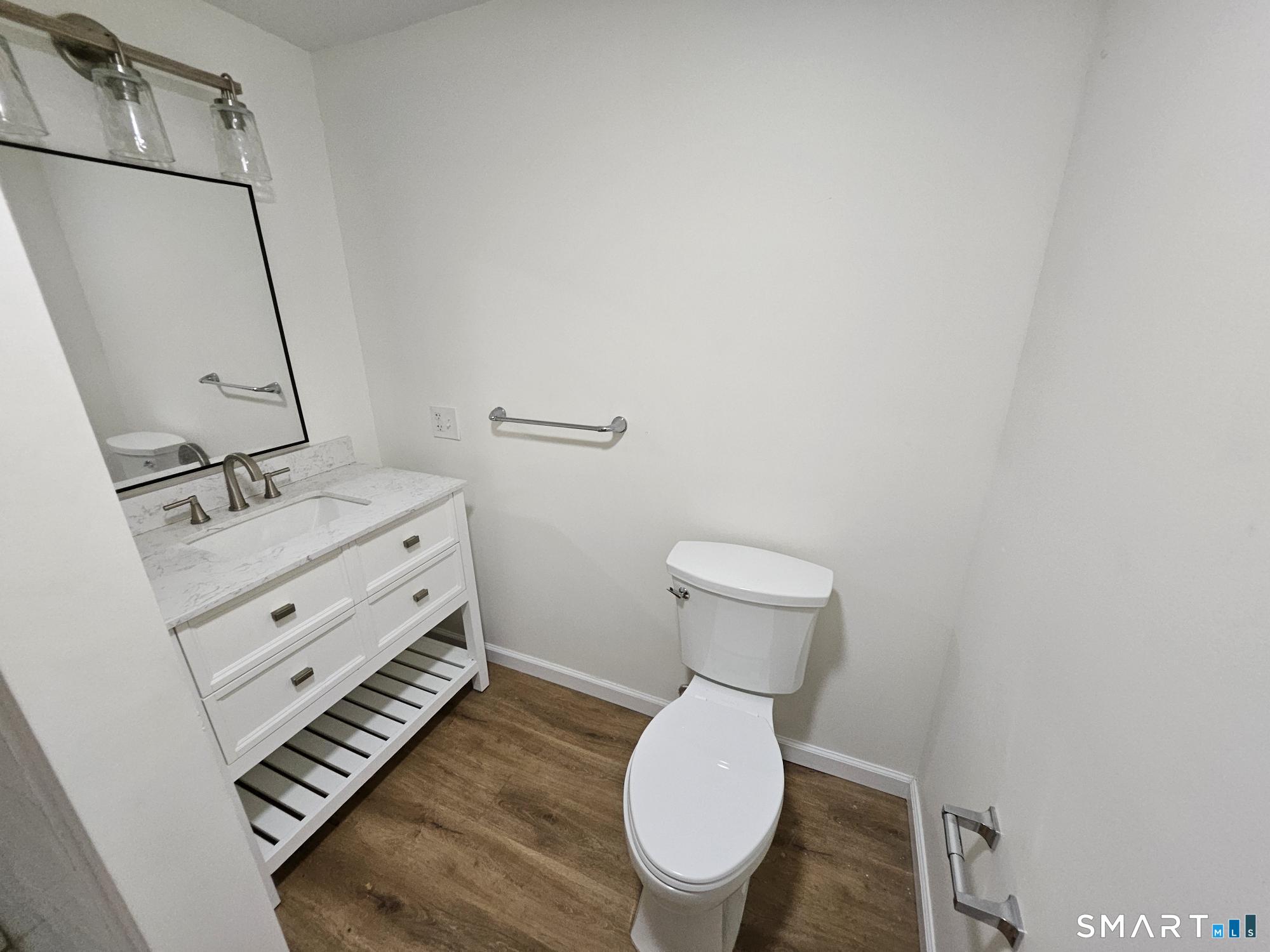 410 Main Street Southington, CT 06489 - Photo 4 of 7 a bathroom with a toilet a sink and mirror