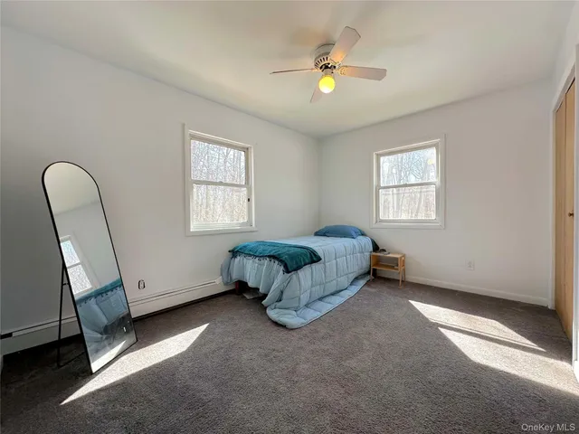 an empty room with windows and chandelier fan