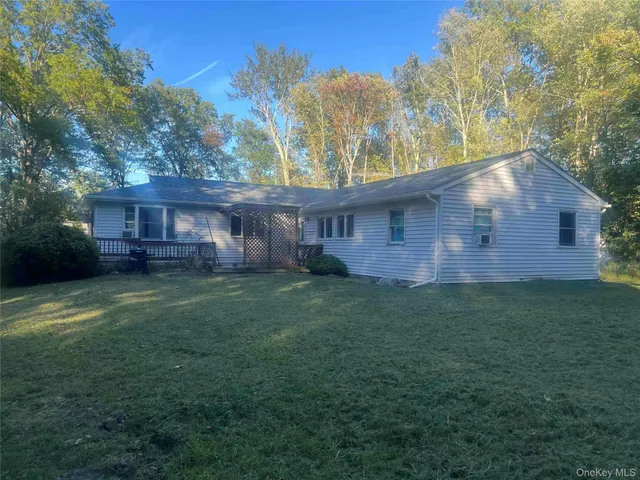 a front view of house with backyard and trees