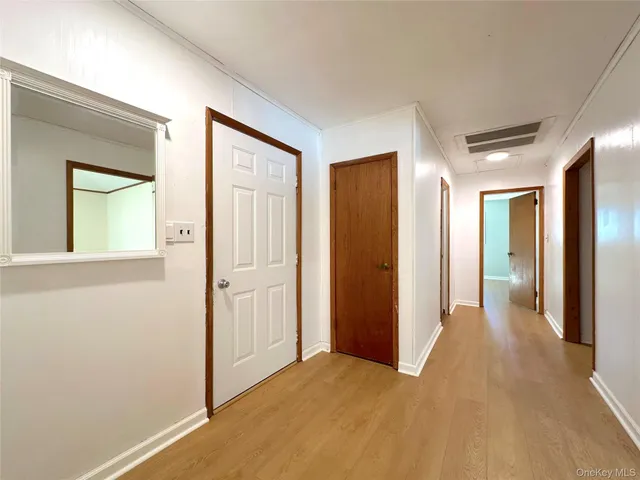 a view of a hallway with wooden floor