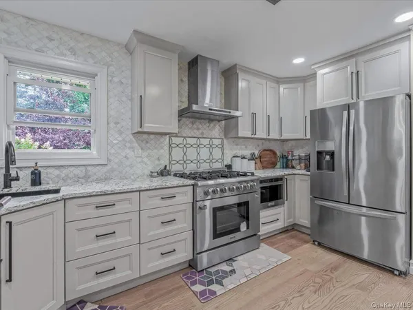 a kitchen with granite countertop a sink stainless steel appliances and cabinets