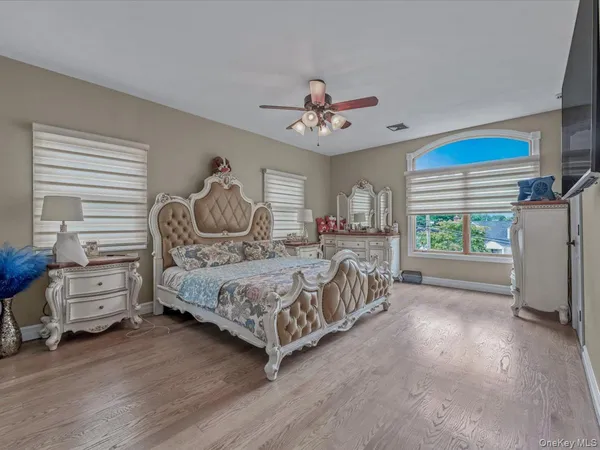 a bedroom with a bed next to a window and a chandelier