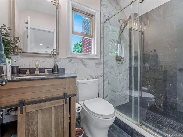 a bathroom with a granite countertop sink a toilet and shower