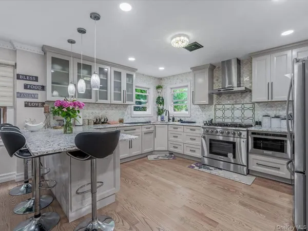a kitchen with kitchen island granite countertop a stove a sink and a refrigerator