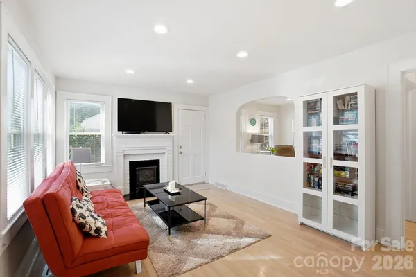 a living room with furniture a fireplace and a flat screen tv
