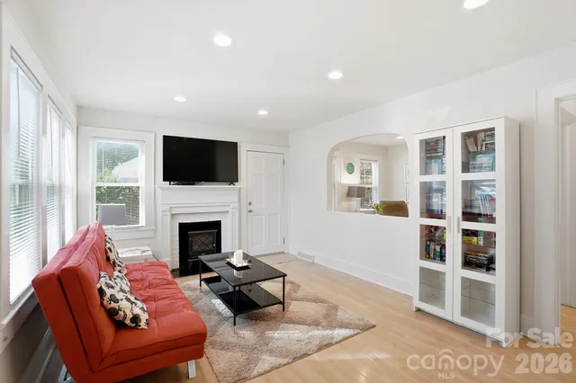 a living room with furniture a fireplace and a flat screen tv