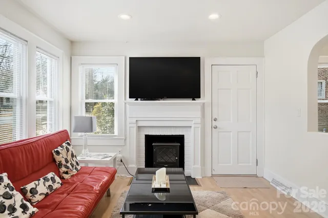 a living room with furniture a flat screen tv and a fireplace