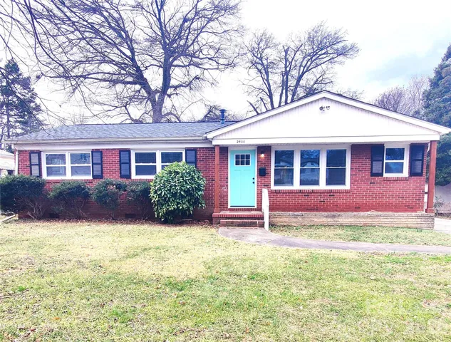 a view of a house with a yard and potted plants