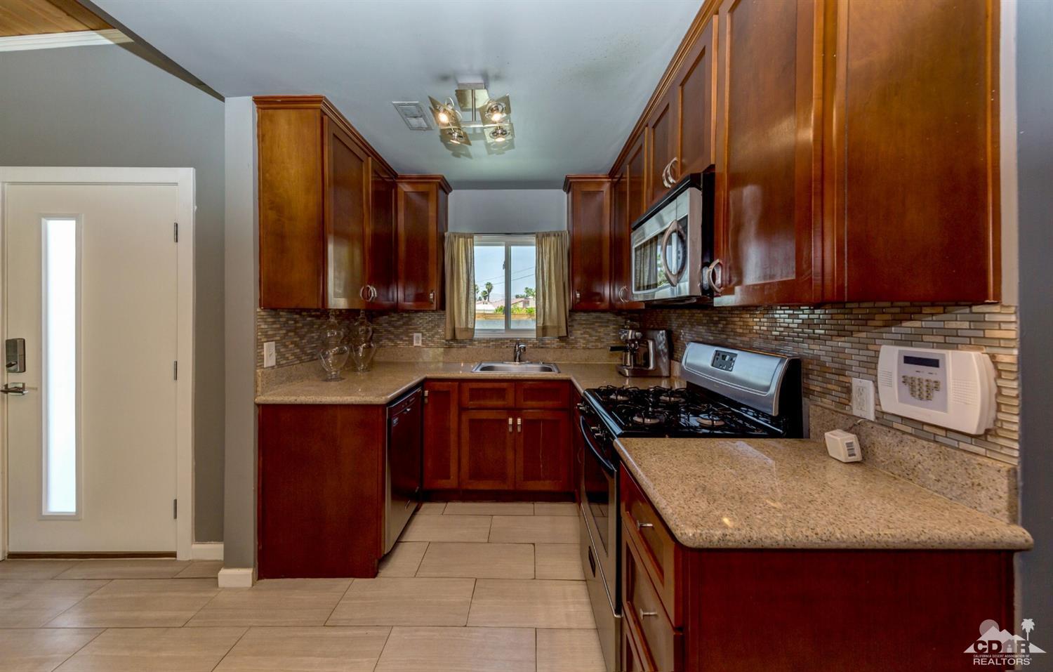 1950 North Magnolia Road Palm Springs, CA 92262 - Photo 11 of 36 a kitchen with stainless steel appliances granite countertop a granite counter tops and a stove