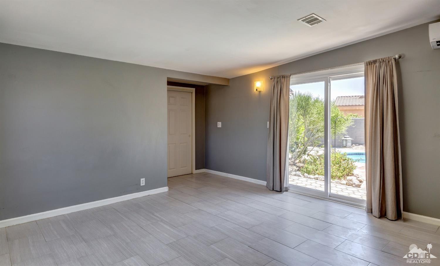 1950 North Magnolia Road Palm Springs, CA 92262 - Photo 13 of 36 an empty room with wooden floor and windows