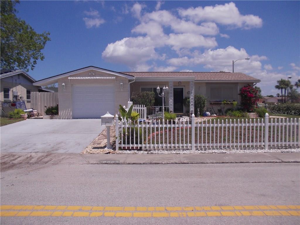 Great curb appeal with picket fence, lamp post, colorful landscaping