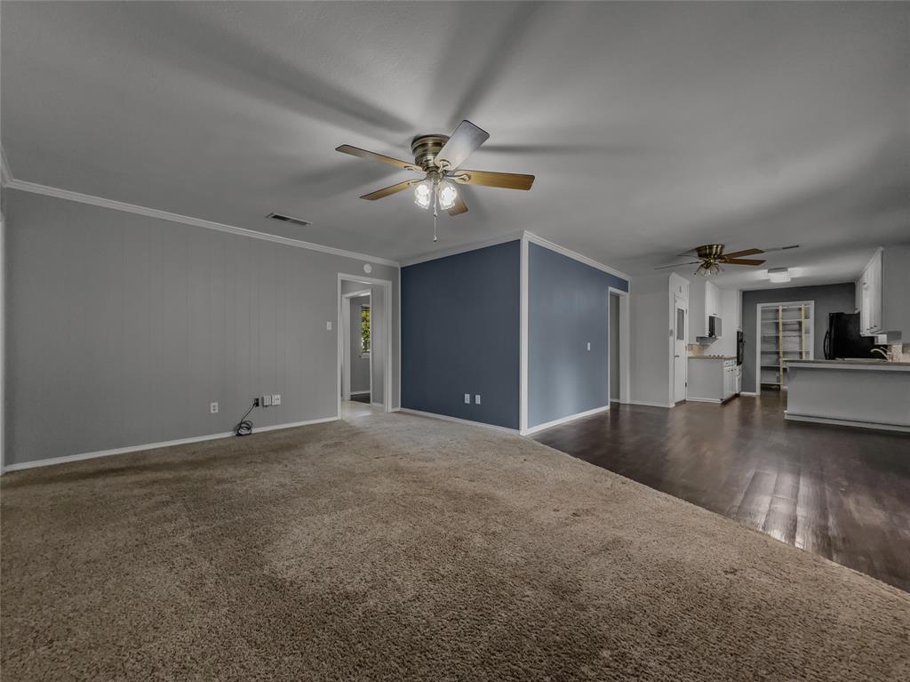220 Cooper Drive Hurst, TX 76053 - Photo 5 of 27 a view of a livingroom with a ceiling fan a ceiling fan and kitchen view