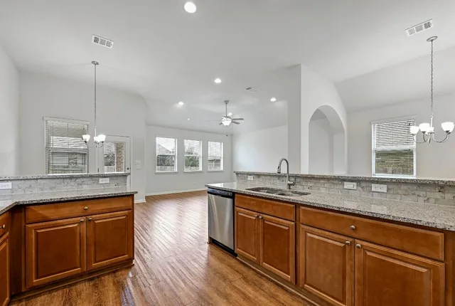 a large kitchen with granite countertop a large white cabinets and sink