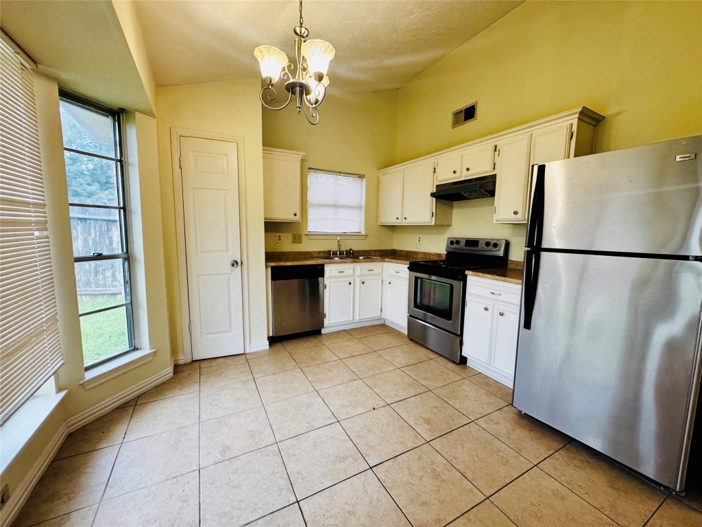 17118 Amber Ridge Drive Sugar Land, TX 77498 - Photo 12 of 20 a kitchen with stainless steel appliances granite countertop a refrigerator a sink dishwasher a stove with wooden cabinets