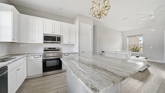 a kitchen with stainless steel appliances a stove sink microwave and cabinets