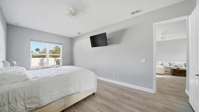 a bedroom with a bed and wooden floor