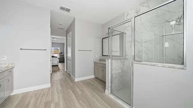 a bathroom with a shower and a glass door
