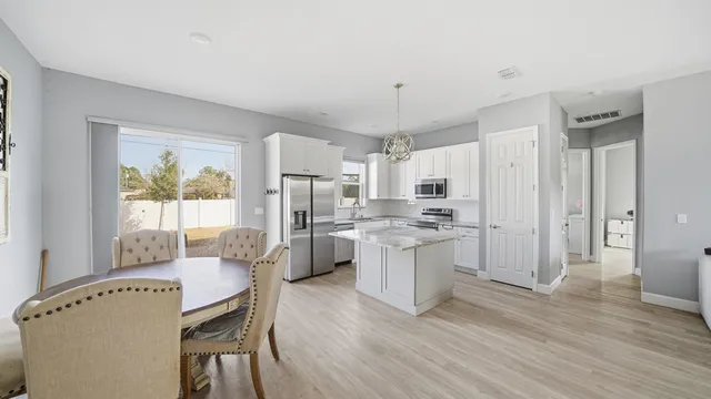 a kitchen with white cabinets and wooden floor