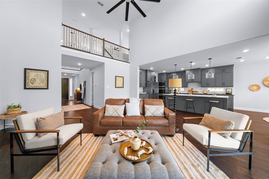 1173 Rochester Place Copper Canyon, TX 75077 - Photo 15 of 34 The property features an open-concept living area with high ceilings, dark hardwood floors, and a ceiling fan