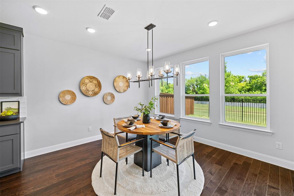 1173 Rochester Place Copper Canyon, TX 75077 - Photo 19 of 34 Dining area featuring hardwood floors, a modern chandelier, and three large windows providing ample natural light