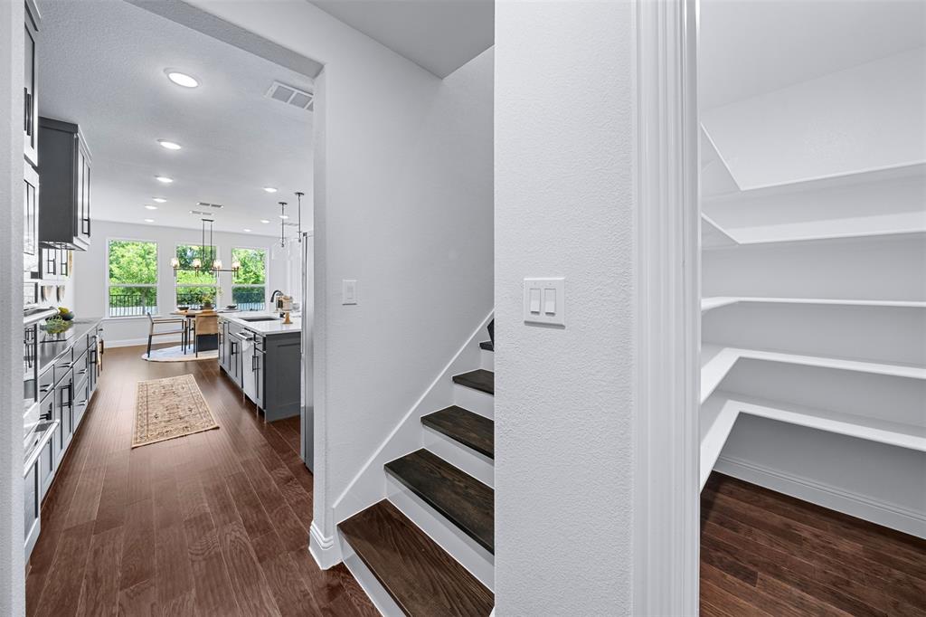 1173 Rochester Place Copper Canyon, TX 75077 - Photo 21 of 34 Open concept living space featuring hardwood floors, a modern kitchen with grey cabinetry, and a dining area with views of green foliage