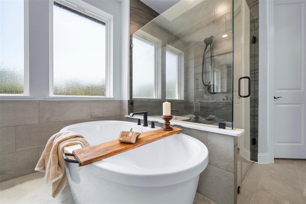 1173 Rochester Place Copper Canyon, TX 75077 - Photo 25 of 34 The bathroom features a freestanding soaking tub and a glass-enclosed shower with a handheld showerhead