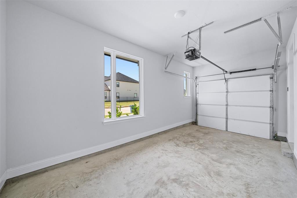 1173 Rochester Place Copper Canyon, TX 75077 - Photo 29 of 34 The garage features a large window providing natural light, a smaller window, and an automatic garage door opener system
