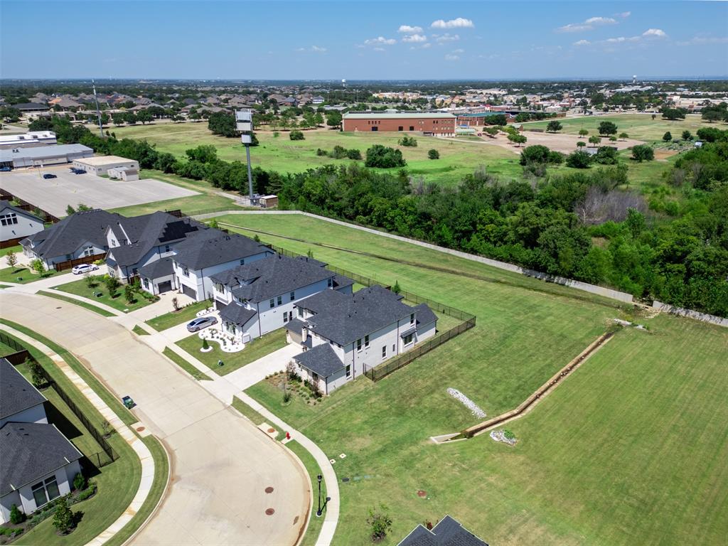 1173 Rochester Place Copper Canyon, TX 75077 - Photo 32 of 34 Aerial view of the property and its surrounding environment, featuring a paved street, green lawns, and mature trees
