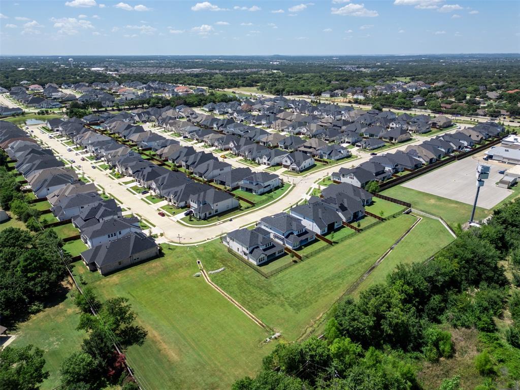 1173 Rochester Place Copper Canyon, TX 75077 - Photo 34 of 34 Aerial view of the community, showcasing streets lined with properties featuring dark roofs, light exteriors, and green lawns