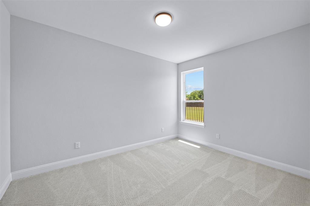 1173 Rochester Place Copper Canyon, TX 75077 - Photo 9 of 34 This room features light gray walls, a window offering views of greenery and sky, and light-colored carpet