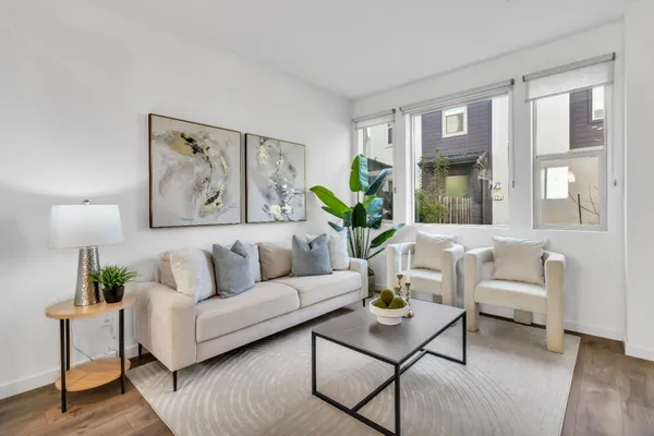 a living room with furniture and a potted plant next to a window