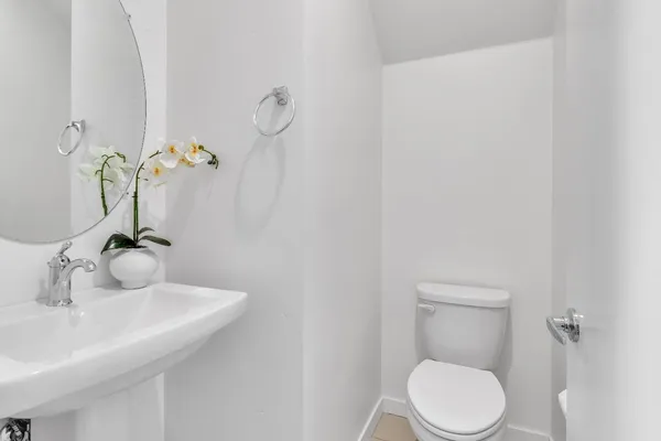 a bathroom with a sink a toilet and a mirror