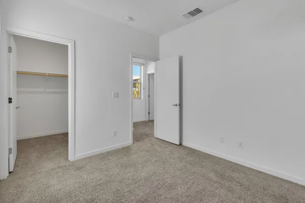 an empty room with windows and closet