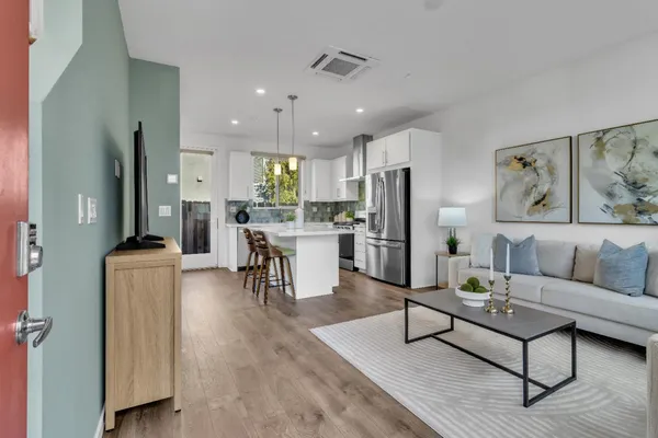 a living room with furniture and a dining table with kitchen view