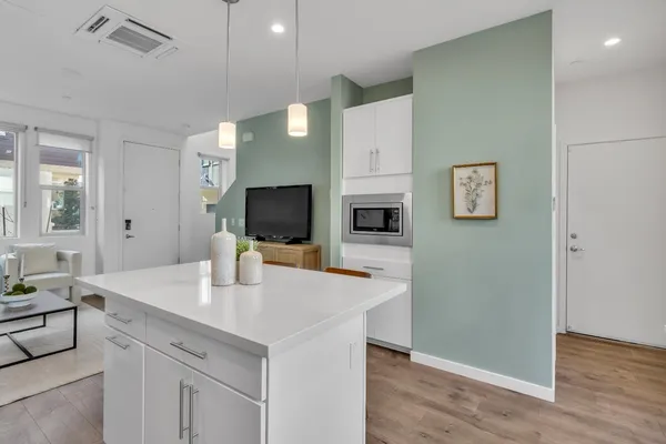 a view of kitchen with stainless steel appliances cabinets and wooden floor